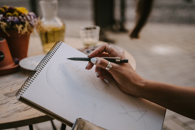 woman drawing on a sketchbook paper