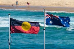 The Australian flag and Australian Aboriginal flag fly side-by-side at Bondi Beach, Sydney in early summer. This image was taken on a windy day in the late afternoon.